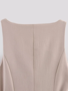 Detail shot of beige sleeveless dress back with central seam and textured fabric finish