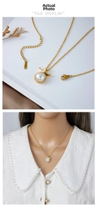 Detailed close-up of a gold-plated crown pendant with a large round white pearl on a chain