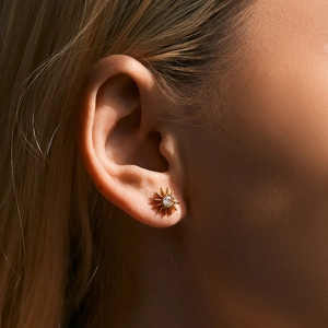 Elegant gold sunflower stud earring with sparkling zircon shown on a model's ear