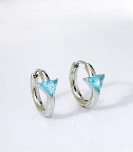 Close-up of silver titanium steel earrings with sky blue triangular zircon stones