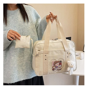 Detail of JK uniform ita bag with heart-shaped window and cute white bear keychain