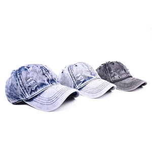 Close-up of vintage distressed denim baseball caps with frayed holes in multiple colors