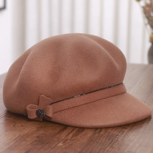 Detailed macro view of the brown wool newsboy cap featuring a rhinestone bow and soft texture
