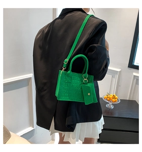 Detailed view of green crocodile texture small tote bag with detachable coin purse accessory