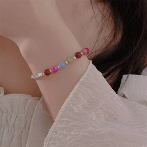 Close-up of colorful beaded bracelet with heart accents and silver metal spacer beads