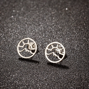 Detail shot of hollow sun and mountain ear studs in silver finish on a black background