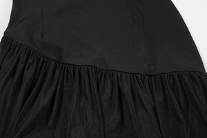 Detail of the black dress featuring a textured weave joined with pleated mesh layers