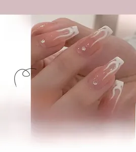 Dettaglio di unghie finte con motivo a fiamma bianca e strass in forma ballerina