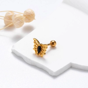 Detailed close-up of a golden butterfly ear stud with a marquise-cut black zircon stone