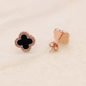 Detail of rose gold clover earrings with black enamel and micro-pave zirconia crystals