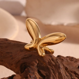 Detailed view of an 18K gold plated butterfly open ring on a dark wooden surface