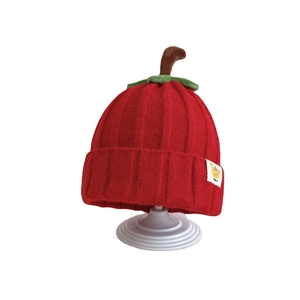 Cute red knitted pumpkin baby hat with green leaf and stem for autumn and winter