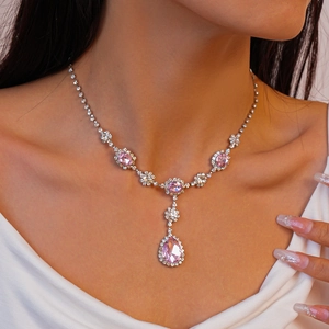 Gros plan d'un collier avec pendentif rose en forme de goutte et diamants sur un mannequin