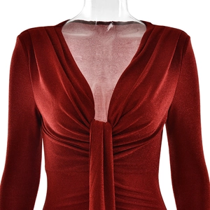 Détail de la robe en velours rouge avec décolleté en V profond, nœud et manches longues