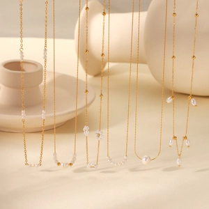 French vintage freshwater pearl and gold chain necklaces set on beige ceramic tray
