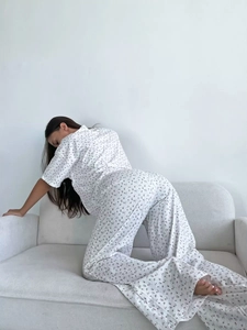 Detail of white two-piece pajama set with cherry floral print and soft cotton fabric
