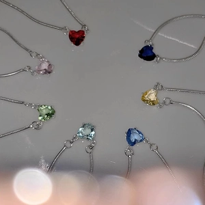 Collection of colorful heart-shaped zircon pendants on silver snake chains in various colors