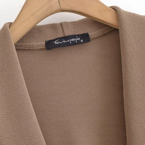 Macro detail of brown cross-neck sleeveless top with woven fabric and For love people label