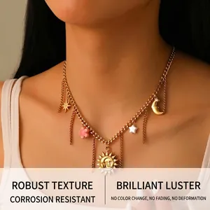 Close-up of gold stainless steel necklace featuring sun, moon, and pink flower charms