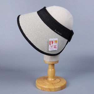 Detail of rollable straw sun hat with black ribbon and UV 99% protection tag