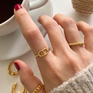 Close-up of gold 925 silver rings with twisted rope and chain texture on model's hand