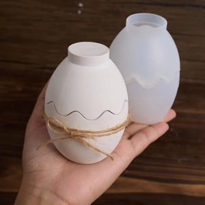 Detail showing an egg-shaped silicone mold and finished plaster craft with wave design