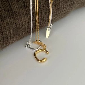Minimalist 925 sterling silver oval irregular pendant necklace on brown sweater