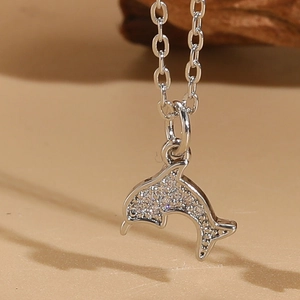 Macro shot of a silver dolphin pendant encrusted with sparkling cubic zirconia on a fine chain