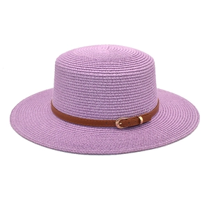 Detail of lavender flat top wide brim straw hat with brown leather band and gold buckle