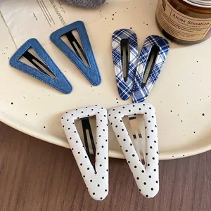 Set di sei fermagli per capelli in tessuto a quadri, pois e righe su un piatto in ceramica