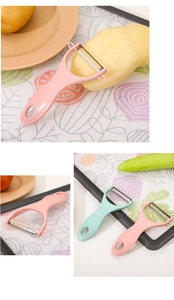 Close-up of a pink ceramic peeler with a sharp stainless steel blade on a wooden board