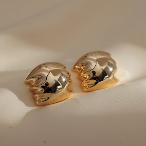 Minimalist gold-plated irregular wavy earrings on a premium cream silk fabric background