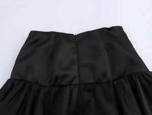 Detail view of the high-waist black satin mini skirt showing back invisible zipper