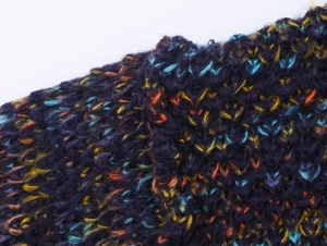Detailed macro view of the colorful mixed-knit fabric on this mock neck sweater