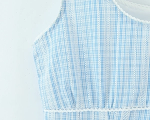 Close-up of blue plaid dress featuring white lace trim and breathable cotton fabric
