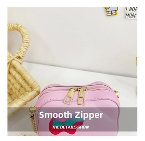 Detail showing smooth gold metal zipper closure on pink leather crossbody bag