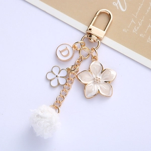 Chic floral keychain with gold letter D pendant and soft white pompom for bags