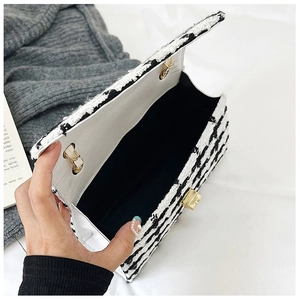 Classic black and white tweed flap bag with gold hardware and woven chain strap