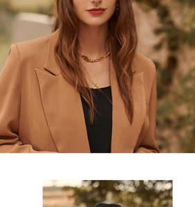 Detail of camel wool blazer paired with layered gold CD necklaces on a model