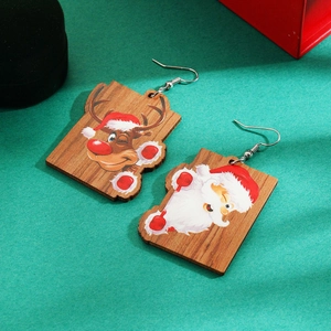 Detailed view of wooden Christmas earrings featuring Santa and reindeer on green background
