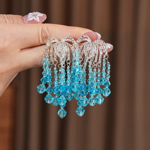 Detail view of sky blue glass beaded fringe earrings with silver chain accents