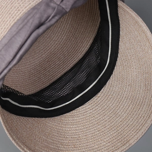 Close-up of the straw sun hat interior with black sweatband and breathable mesh lining