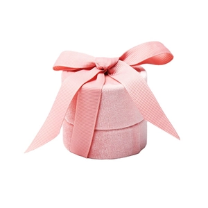 Elegant pink velvet round jewelry box with a matching ribbon bow on white background