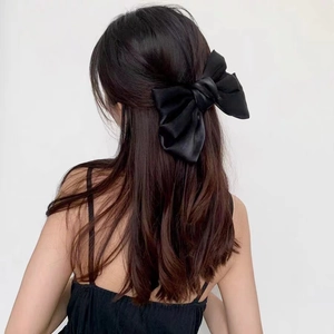French vintage black pearlescent satin bow hair clip shown on the back of the head