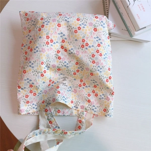 Close-up of floral cotton tote bag with vintage flower patterns on a white table