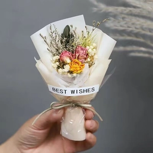 Close-up of a mini dried flower bouquet with pink and yellow roses and Best Wishes tag
