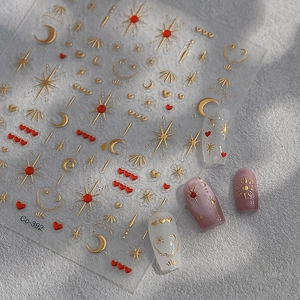 Matte gold embossed nail stickers with stars, moons, and hearts motifs with sample tips