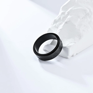 Macro shot of matte black Eye of Horus stainless steel spinner ring on a white stone