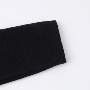 Detaillierte Makroansicht der Strickstruktur und Verarbeitung am Ärmel des schwarzen Kleides