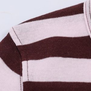 Close-up of the shoulder seam and collar detail on striped brown and pink knit sweater